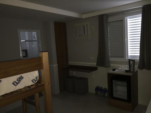 Kleines Zimmer mit einem Bett, einem Fenster und einem Fenster in der Unterkunft Hotel Flor do Ipiranga (Adult Only) in São Paulo