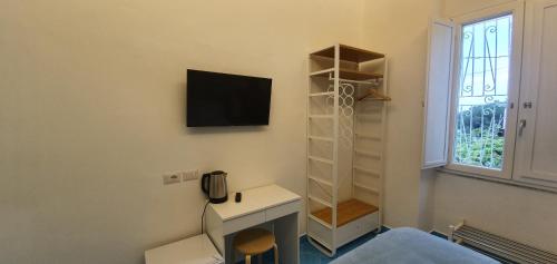 a room with a tv on a wall with a desk at B&B FISH in Vietri sul Mare