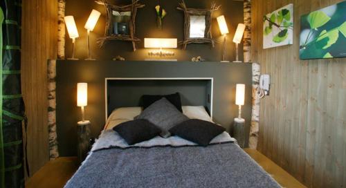 a bedroom with a bed with three pillows on it at Hotel Le Rocher Blanc in Albaret-Sainte-Marie