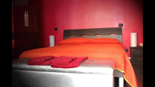 a bedroom with red walls and a bed with red sheets at La Pinetina Roma in Rome