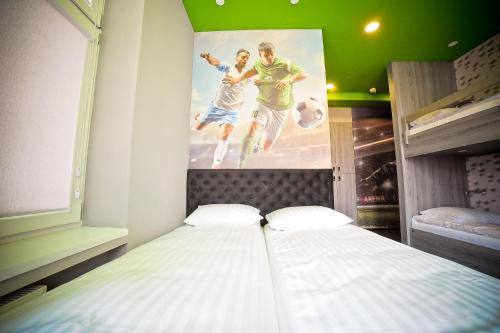 a bed in a room with a poster on the wall at Olympic - Old Town in Gdańsk