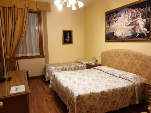 a hotel room with two beds and a painting on the wall at Hotel La Rosa in Ronta