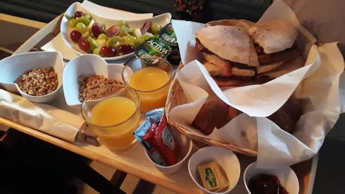 een dienblad met eten, een broodje en een schaal fruit bij Birdsong Cottage Bed and Breakfast in Chathill