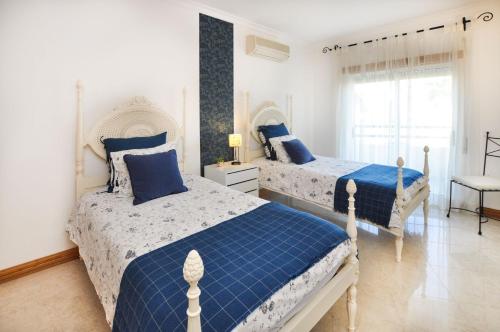 Duas camas num quarto com azul e branco em Galé Mar by OCvillas em Albufeira