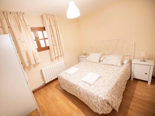 um quarto com uma cama com uma colcha branca em Espacios Blanco Plaza del Viejo Coso em Valladolid