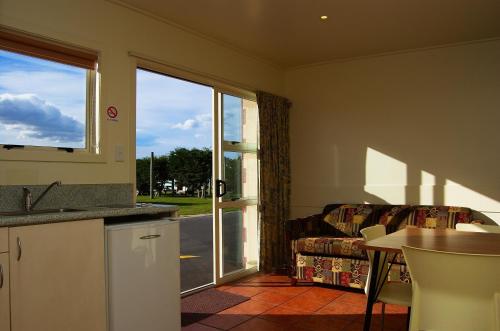 een keuken en een woonkamer met een bank en een tafel bij Dunedin Holiday Park in Dunedin