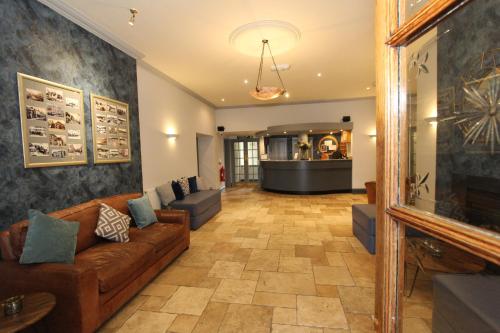 sala de estar con sofá y chimenea en Gwesty Nanhoron Arms Hotel, en Nefyn