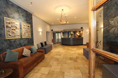 a living room with a couch and a fireplace at Gwesty Nanhoron Arms Hotel in Nefyn
