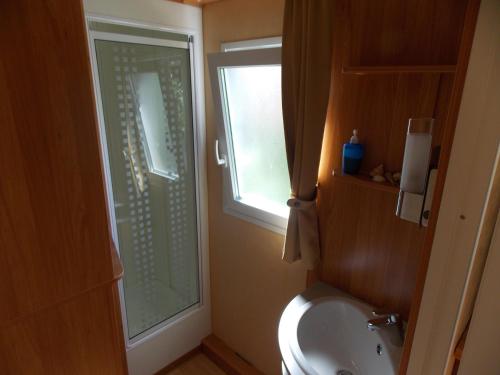 a bathroom with a toilet and a sink and a window at Holiday home Rozika in Slovenj Gradec