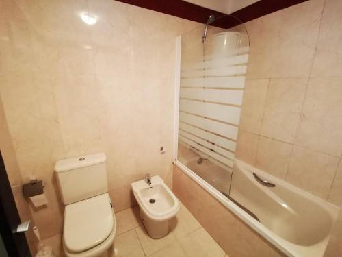 a bathroom with a toilet and a bath tub at Beautiful Apartment in Palm-Mar