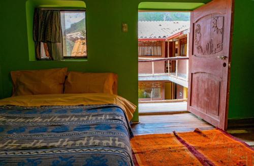 1 dormitorio con cama y pared verde en Wayna Wasi, en Písac