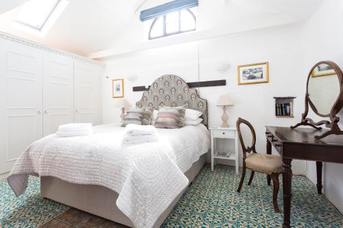 a bedroom with a bed and a desk and a piano at The Old Stables in Docking