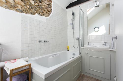 a white bathroom with a tub and a sink at The Old Stables in Docking