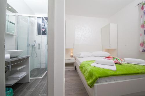 a white bathroom with two beds and a shower at Villa Matić in Makarska