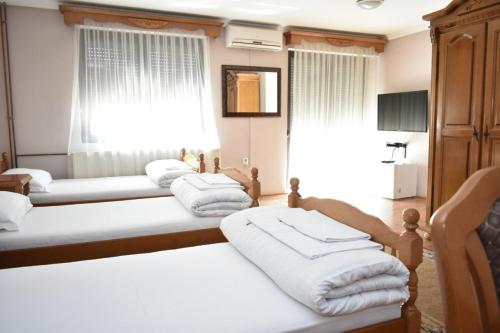 een kamer met 3 bedden en witte dekens bij Vidikovac-Berane in Berane