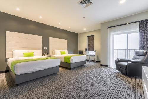 een hotelkamer met 2 bedden en een stoel bij The Wallhouse Hotel, Ascend Hotel Collection in Walnut Creek