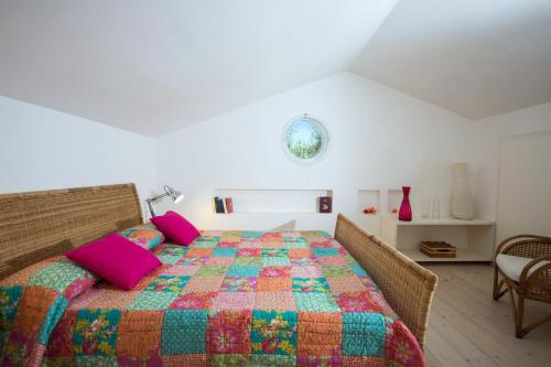 a bedroom with a bed with a colorful quilt at Villa Jasmine con piscina privata in Donnalucata