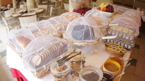 a table with many baskets of food on it at Atena Praia Hotel in Boicucanga