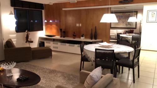 sala de estar y cocina con mesa y sofá en Apartamento com 3 Suites em Bairro nobre, próximo ao Centro de Eventos do Ceara en Fortaleza
