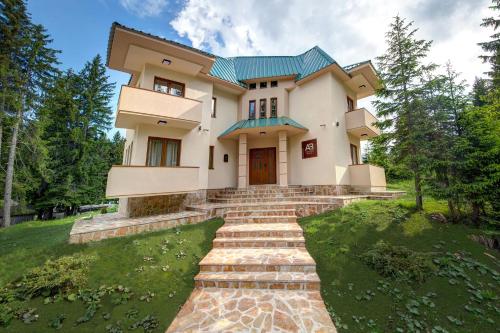 una casa con una escalera que conduce a ella en Apartmani Bijelic en Žabljak