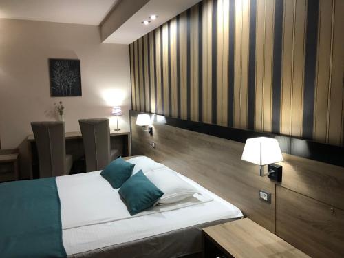 a bedroom with a bed with two blue pillows at Pensiunea Lido in Piatra Neamţ