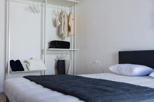 a bedroom with a bed with a black blanket and clothes at vilamaria apartment in Porches