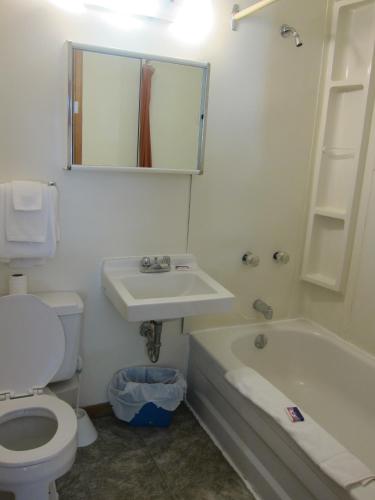 a bathroom with a toilet and a sink and a tub at Shine Motel in Summerside