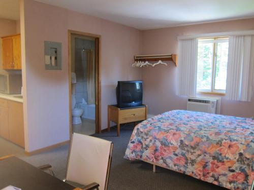 a bedroom with a bed and a tv in it at Shine Motel in Summerside