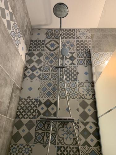 a bathroom with a shower with blue and white tiles at LACANAU FRONT DE MER in Lacanau