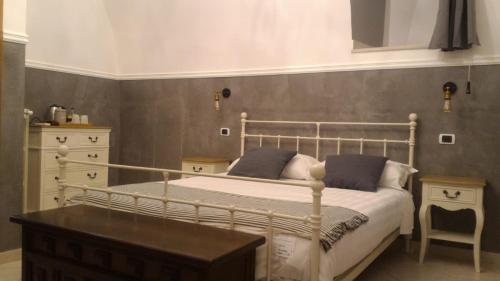 a bedroom with a bed and a table and a mirror at Il Vicolo - Affittacamere in Ruvo di Puglia
