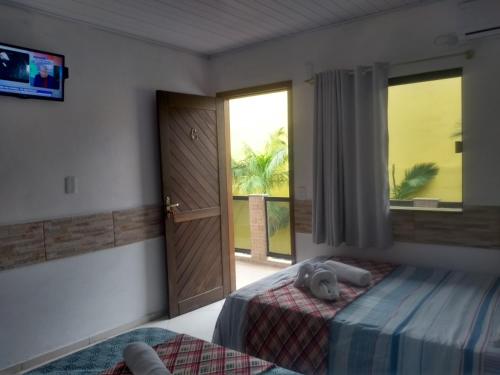 a bedroom with a bed and a sliding door at Pousada Vó Nita in Penha