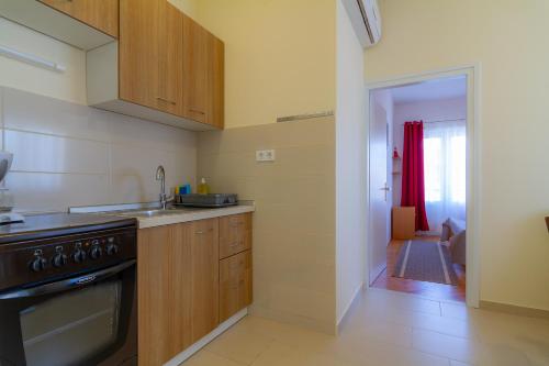 a kitchen with a sink and a stove top oven at Apartments & Rooms Sanja in Rab