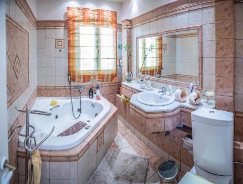 a bathroom with a tub and a sink and a toilet at Villa Virginia in Vonitsa