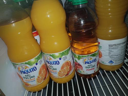 a refrigerator filled with bottles of orange juice at Hotel des voyageurs Chez Betty in Neussargues-Moissac