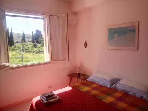 um quarto com uma cama e uma janela em Villetta San Giovanni em Calatafimi