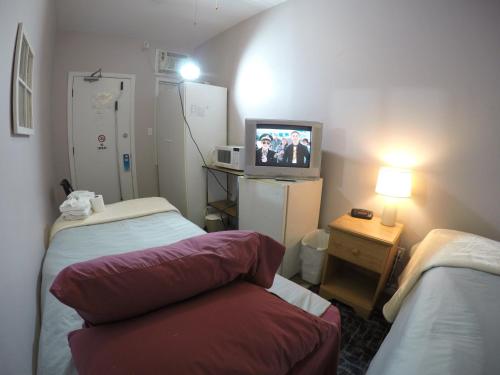 um quarto de hospital com duas camas e uma televisão em Saint Lawrence Residences and Suites em Toronto
