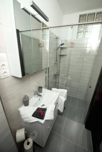 a white bathroom with a sink and a shower at Lakefive Apartments Balatonfüred in Balatonfüred