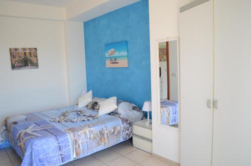 ein Schlafzimmer mit einem Bett und einer blauen Wand in der Unterkunft Santanna Beach House - Fondachello-apartments com in Mascali