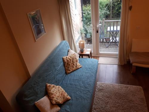 a blue couch in a living room with a window at Bramblhen in Nottingham