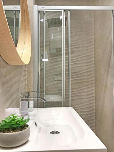 a bathroom with a white sink and a shower at Apartments Tessera in Split