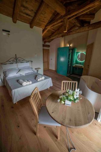 una camera da letto con un letto, un tavolo e delle sedie di Tenuta Armonia a Clavesana