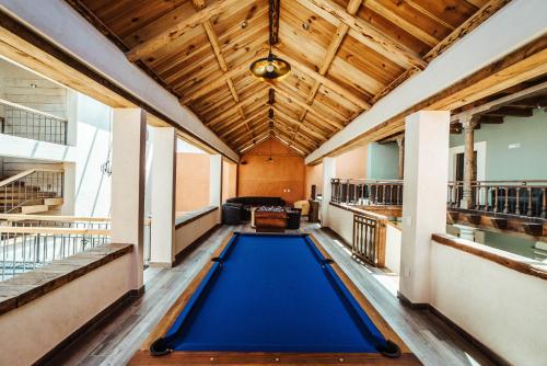 - une grande piscine bleue dans une chambre dotée de plafonds en bois dans l'établissement Kotantik bed & breakfast, à San Cristóbal de Las Casas