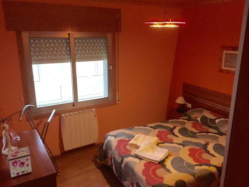 1 dormitorio con cama, escritorio y ventana en Apart. cerca de Playa Catedrales en Lourenzá