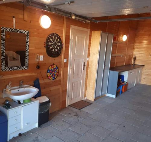 a bathroom with a sink and a mirror and a door at Domek na Cichej Leśniewo in Leśniewo