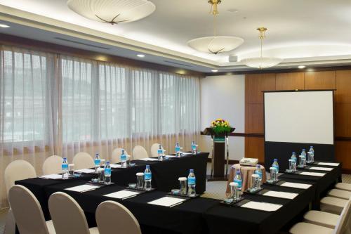 a conference room with tables and chairs and a screen at HiONE Holiday Hotel in Shenkeng