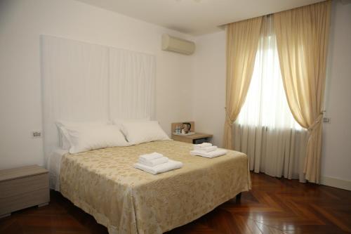 a bedroom with a bed with two towels on it at Champagne Rooms in Sirmione