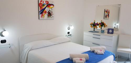 a white bedroom with a bed and a dresser at Da Zia Pina in Minori