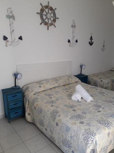 a bedroom with a bed and two nightstands and a bed with a white at Casa Barbara in Marzamemi