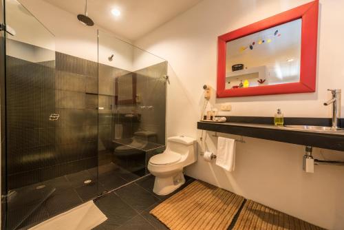 a bathroom with a toilet a sink and a mirror at Casa Harb Hotel Boutique in San Andrés