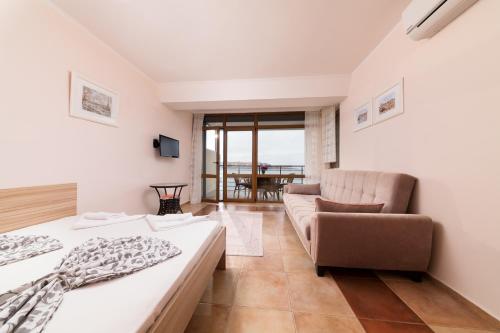 ソゾポルにあるSozopol Seaside Apartmentのベッドルーム1室(ベッド2台、ソファ、テーブル付)